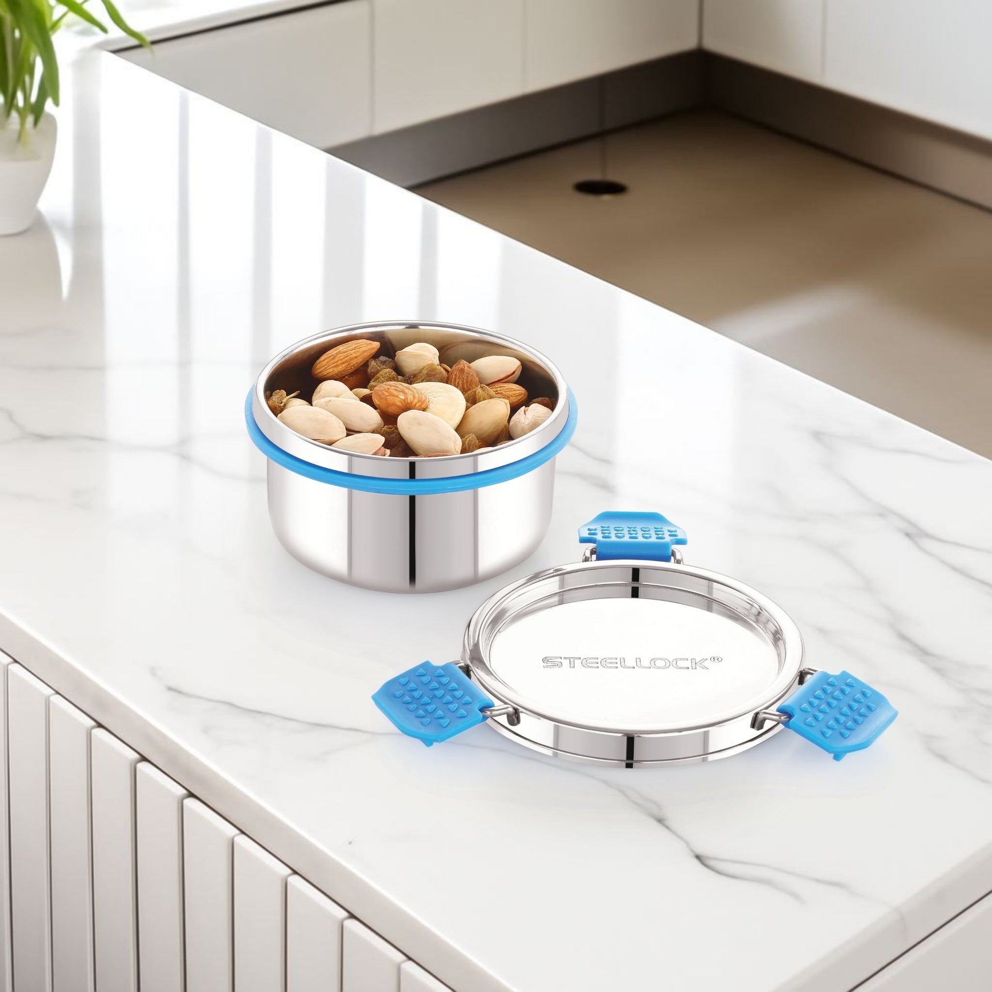 Stainless steel food container with blue straps on a kitchen counter