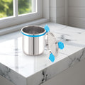 Stainless steel container with blue handles on a marble surface