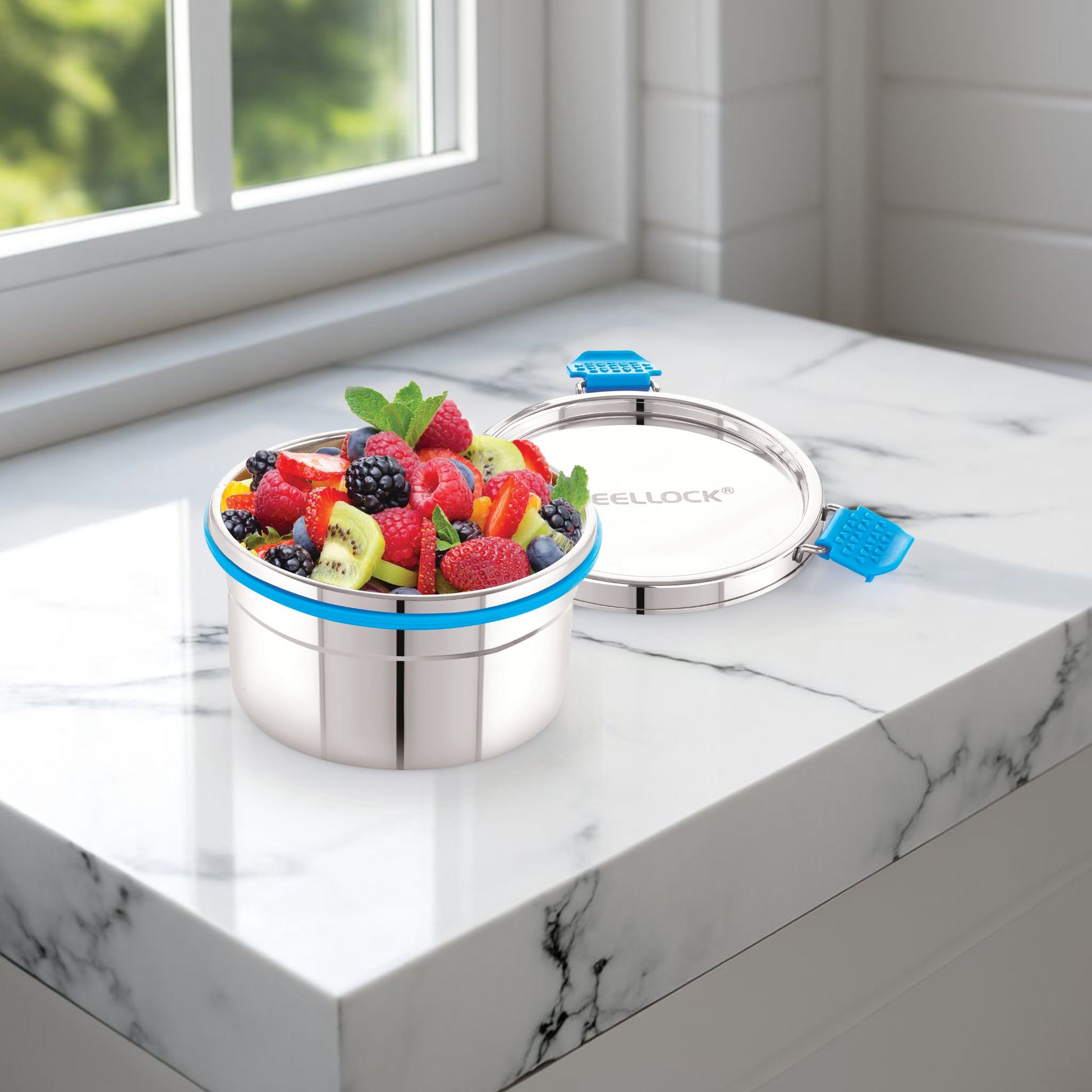 Stainless steel container with colorful fruit salad on a marble surface