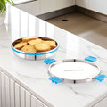 Stainless steel food storage container with blue lids on a kitchen counter