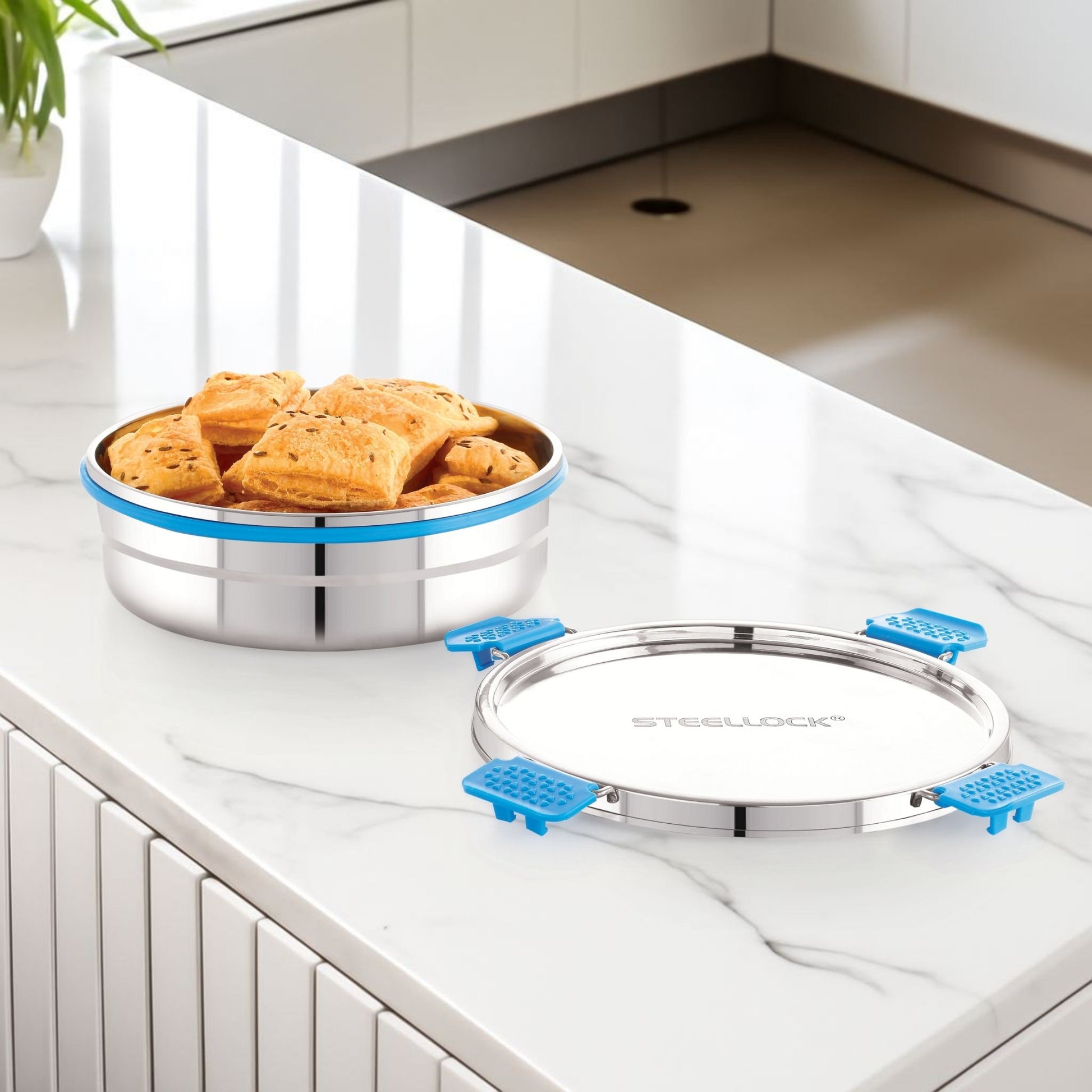 Stainless steel lid with blue silicone seals on a kitchen counter