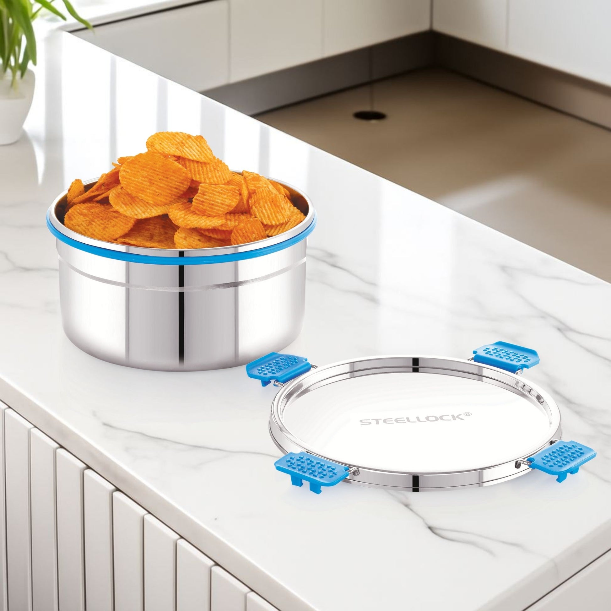 Stainless steel container with blue seals on a kitchen counter, filled with orange chips.