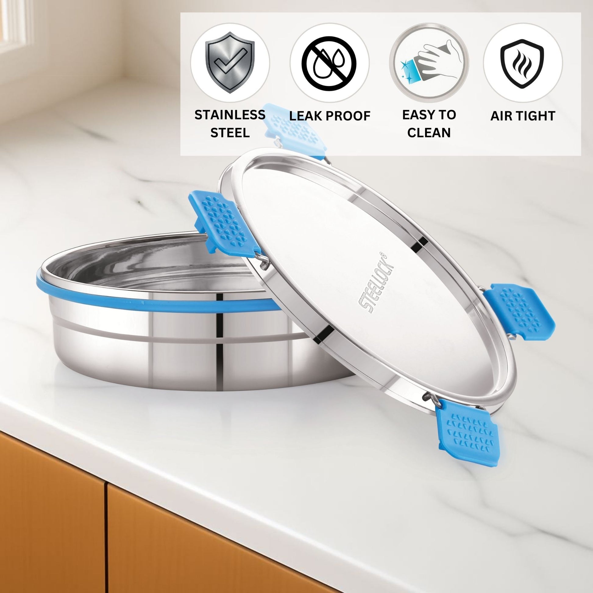 Stainless steel container with blue silicone grips on a kitchen counter, featuring icons for stainless steel, leak proof, easy to clean, and air tight.